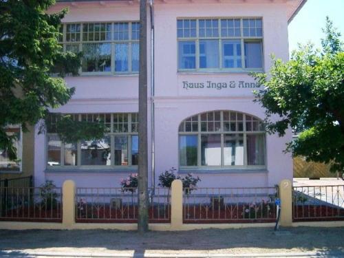 a pink house with a fence in front of it at Villa Inga & Anne in Ahlbeck