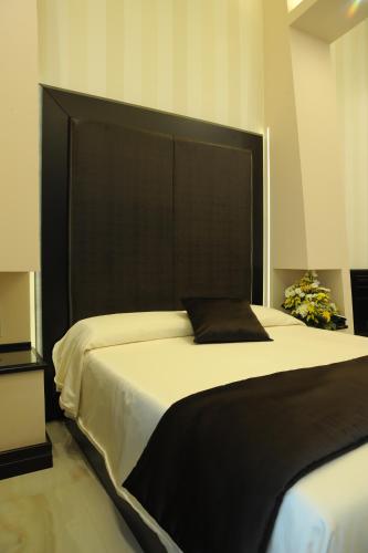 a bedroom with a large bed with a black headboard at Muro Torto suite - Struttura sanificata giornalmente con ozono e prodotti specifici conformi al Decalogo del Ministero Salute - Personale sottoposto a test sierologico periodicamente in Foggia