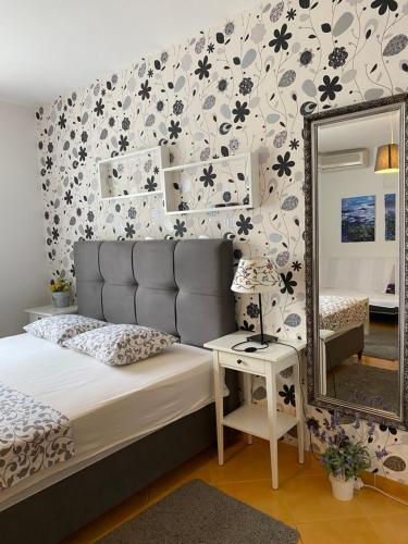 a bedroom with a bed and a mirror at Apartment Lara in Rab