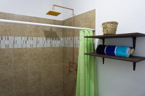 uma casa de banho com um chuveiro com uma cortina de chuveiro verde em Hacienda bambú em Bacalar