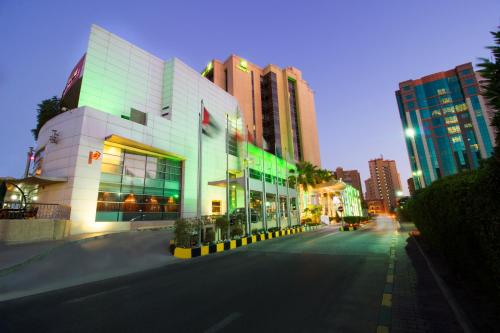 a city street at night with buildings and a street at Holiday Inn - Suites Kuwait Salmiya, an IHG Hotel in Kuwait