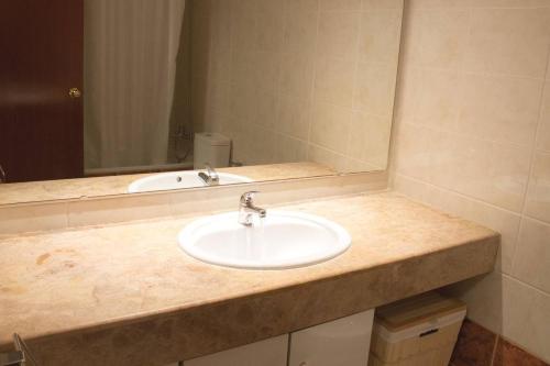 um balcão de casa de banho com um lavatório e um espelho em Domatsea Salou Mediterrani em Salou