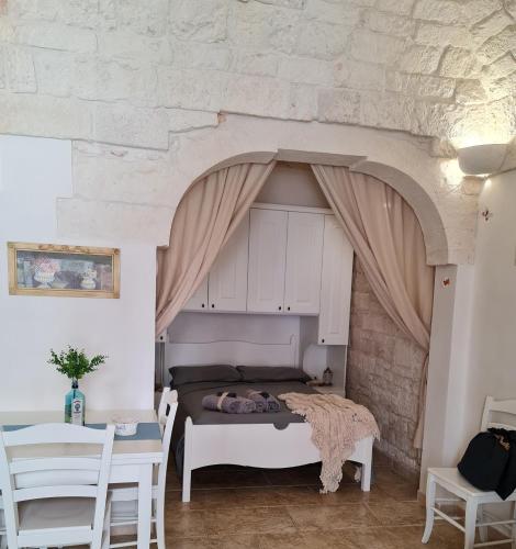 a bed in a room with a stone wall at BiancoAmore OSTUNI - the sky, the sea, the love - in Ostuni