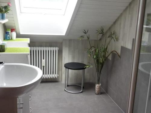 baño con lavabo, mesa y taburete en Ferienwohnung Gerda Weiß, en Allensbach