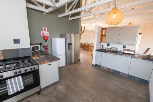 a kitchen with white cabinets and a stove and refrigerator at Antares Bush Camp & Umgede Hide in Grietjie Nature Reserve