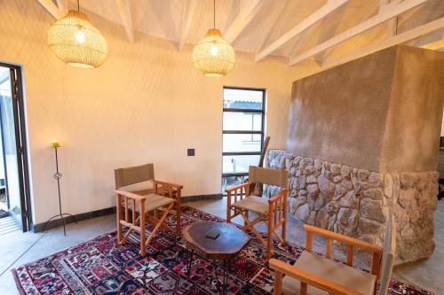 a room with chairs and a stone wall at Antares Bush Camp & Umgede Hide in Grietjie Nature Reserve