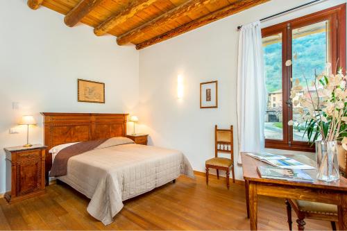 a bedroom with a bed and a desk and a window at B&B Borgo Castello in Marostica