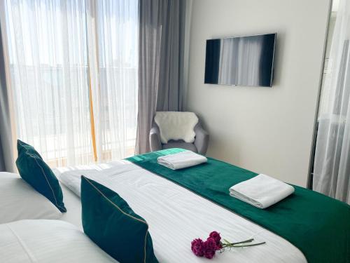 une chambre d'hôtel avec un lit orné d'une fleur dans l'établissement GA Luxury Apartments M45, à Cracovie