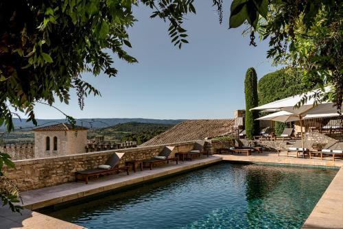 a swimming pool with lounge chairs and a house at Hotel Crillon le Brave in Crillon-le-Brave