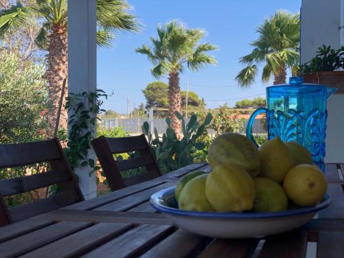 a bowl of fruit on a wooden table on a porch at Ca' del Sale 97 in Marsala