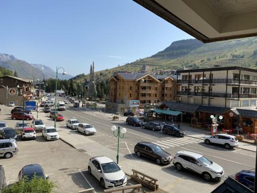a city with cars parked in a parking lot at Boost Your Immo Les Deux Alpes Kandahar 357 in Les Deux Alpes