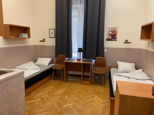 Zimmer mit 2 Betten und einem Tisch mit Stühlen in der Unterkunft Guest Rest Studio Apartments in Budapest