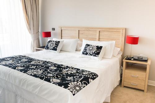 a bedroom with a bed with a black and white comforter at Apartamentos Terrazas de Talca in Talca
