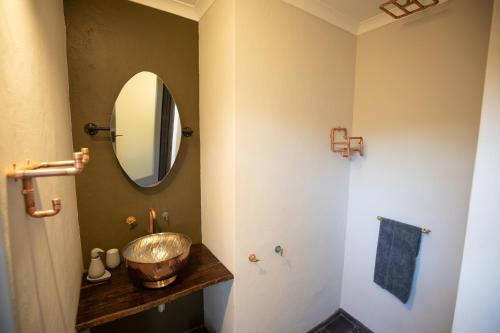 a bathroom with a sink and a mirror at Antares Bush Camp & Umgede Hide in Grietjie Nature Reserve