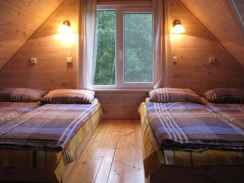 ein Schlafzimmer mit zwei Betten in einer Blockhütte in der Unterkunft Latava in Anykščiai