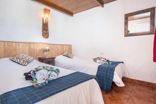 two beds in a room with white walls and wooden floors at Casa Verode - Villa Perenquén in Guía de Isora