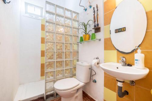 un bagno con un water, un lavandino e uno specchio di Casa Verode - Villa Perenquén a Guía de Isora