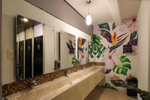 a bathroom with mirrors and flowers on the wall at Hostal Gayser in Valladolid