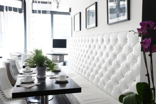 a dining room with a white tufted bench at Business Wieland Hotel in Düsseldorf
