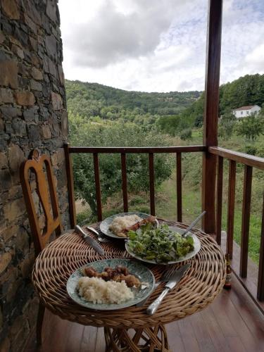 a table with two plates of food on a balcony at Casa do Rebelhe in Bragança