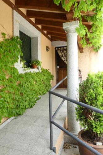 a porch of a house with a column and plants at Casa del Portalón in Ituero y Lama
