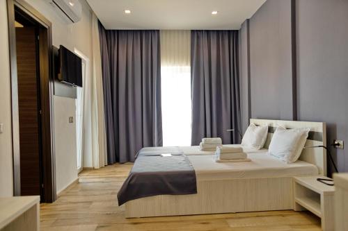 a bedroom with a large bed and a television at Pensiunea Mara in Techirghiol