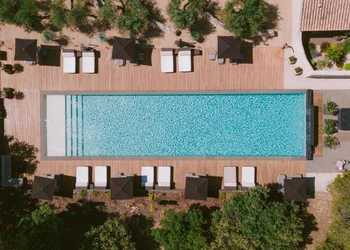 een uitzicht over het zwembad met ligstoelen bij Domaine la Pierre Blanche in Eygalières