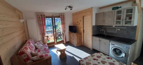 un salon avec un canapé et une cuisine dans l'établissement Appartement Saint Gervais les Bains, à Saint-Gervais-les-Bains