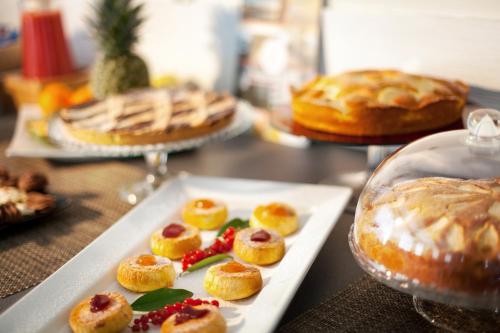 un tavolo con un piatto di dolci e torte di My Place Hotel a Rimini