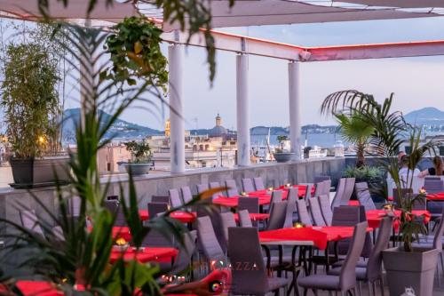 a restaurant with red tables and chairs on a roof at Hotel Terme Neronensis in Pozzuoli