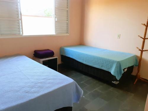 dwa łóżka w pokoju z oknem i dwa bedsvisor w obiekcie Franca Maya Hostel w mieście Campinas