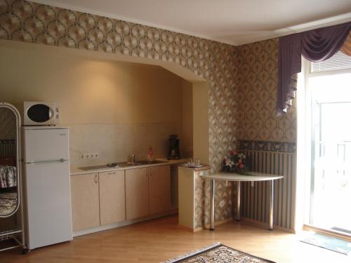 a kitchen with a white refrigerator and a sink at Oasis Apartments in Pärnu