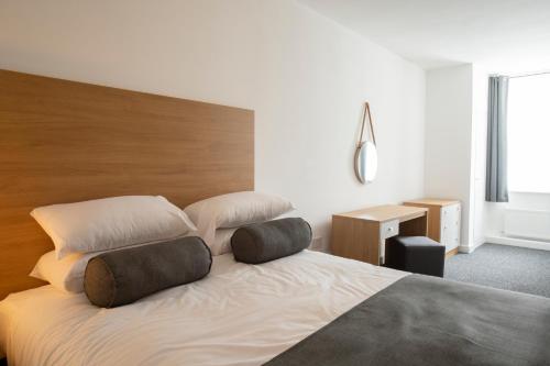 a bedroom with a bed with two pillows on it at Wellington Apartments in Norwich
