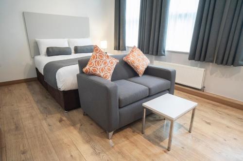a living room with a bed and a couch and a chair at Wellington Apartments in Norwich