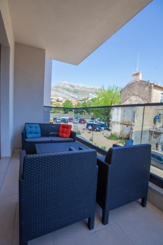 a balcony with two chairs and a couch and a window at Apartman Exclusive Trebinje Centar in Trebinje