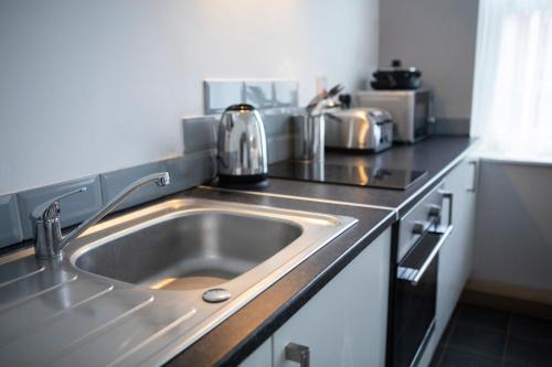 a kitchen counter with a sink in a kitchen at Wellington Apartments in Norwich