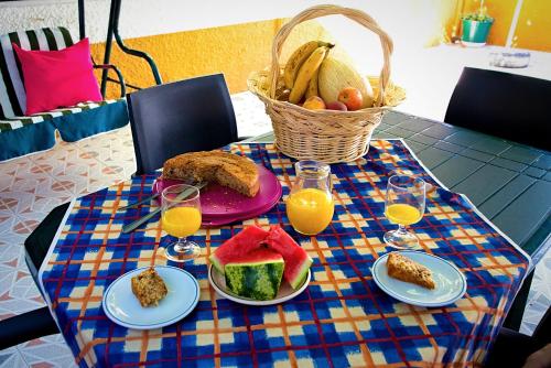 a table with a plate of food and glasses of orange juice at Alojamento Local Familiar in Monfortinho