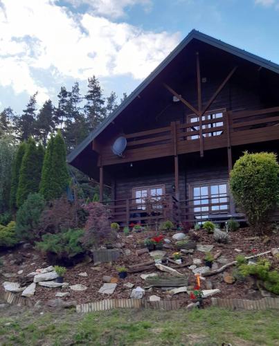 a log cabin with a garden in front of it at Dom Na Wzgórzu 479, The House on the hill in Sułkowice