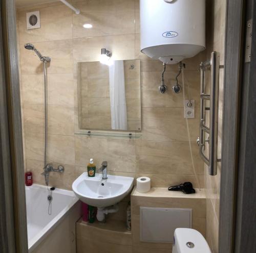 a bathroom with a sink and a toilet and a mirror at Апартаменты метро Тараса Шевченко in Kyiv