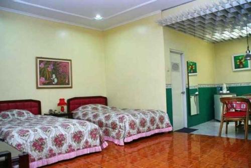 1 Schlafzimmer mit 2 Betten, einem Tisch und Stühlen in der Unterkunft hotel susana baru in Tegal
