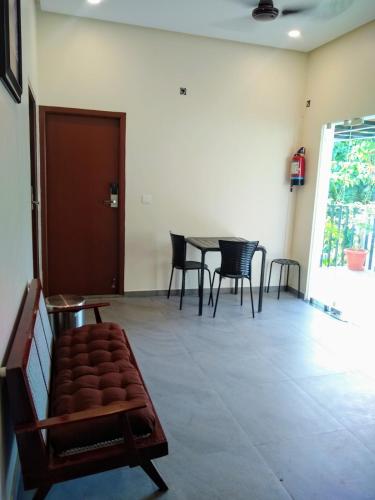 Zimmer mit einem Tisch, Stühlen und einem Sofa in der Unterkunft Avea Accommodation in Madurai