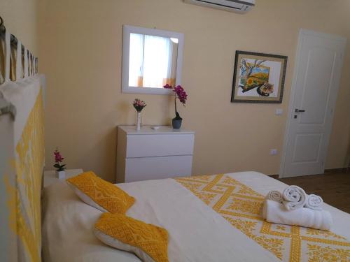 a bedroom with a bed with towels on it at Le Orchidee in Bosa