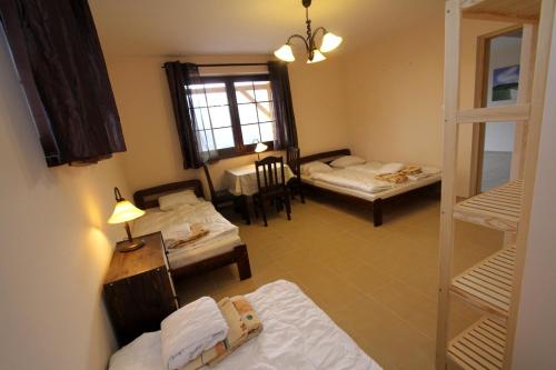a room with two beds and a table with a window at Siwejka - Ropki - Beskid Niski in Ropki
