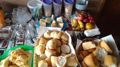 a table topped with different types of bread and fruit at Pousada Guadalupe in Aparecida