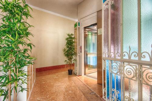 a hallway with potted plants and an open door at Lady Verona Residence in Verona
