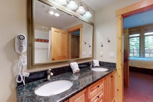 baño con 2 lavabos y espejo grande en Taylor's Crossing 109, en Copper Mountain
