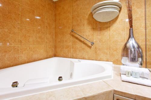 a bathroom with a white tub and a large vase at Holiday Inn Express Monterrey Galerias-San Jeronimo, an IHG Hotel in Monterrey