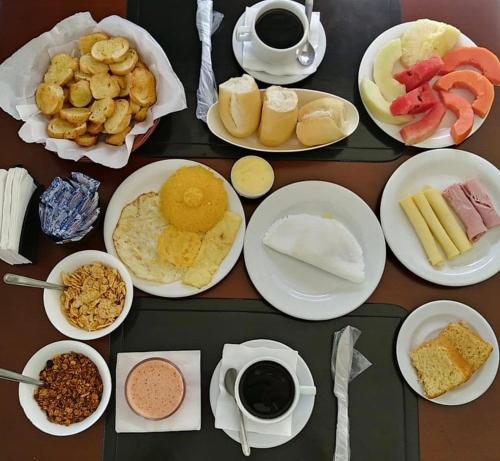 a table topped with plates of food and cups of coffee at Trópico Praia Hotel in Maceió