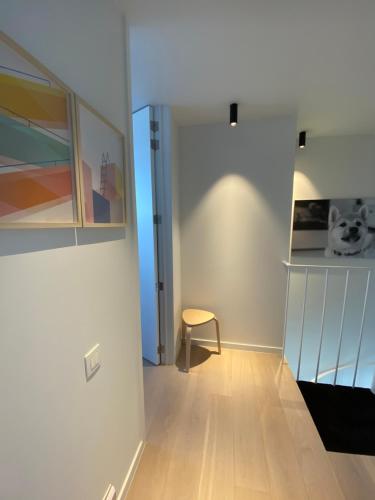 a hallway with a chair and a wall at Coxy Penthouse Koksijde in Koksijde