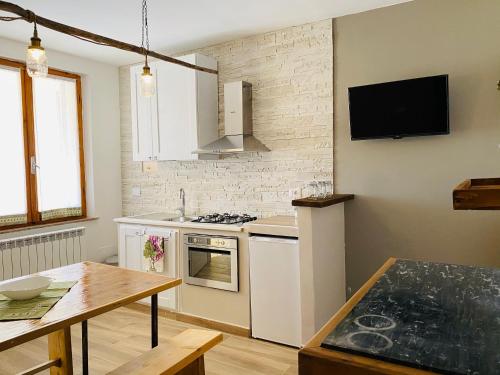 uma cozinha com electrodomésticos brancos e uma mesa de madeira em Agriturismo Casa Orsini em Montefalco